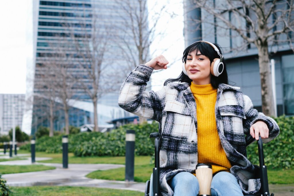 Confident Woman in Wheelchair Flexing Arm Muscle