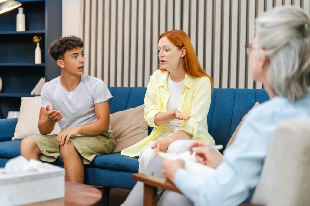 Mother and son having conversation with therapist