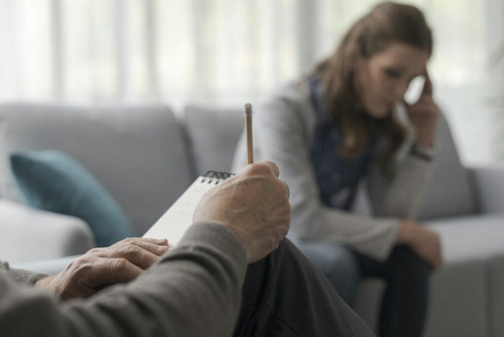 Psychologist writing notes during a therapy session