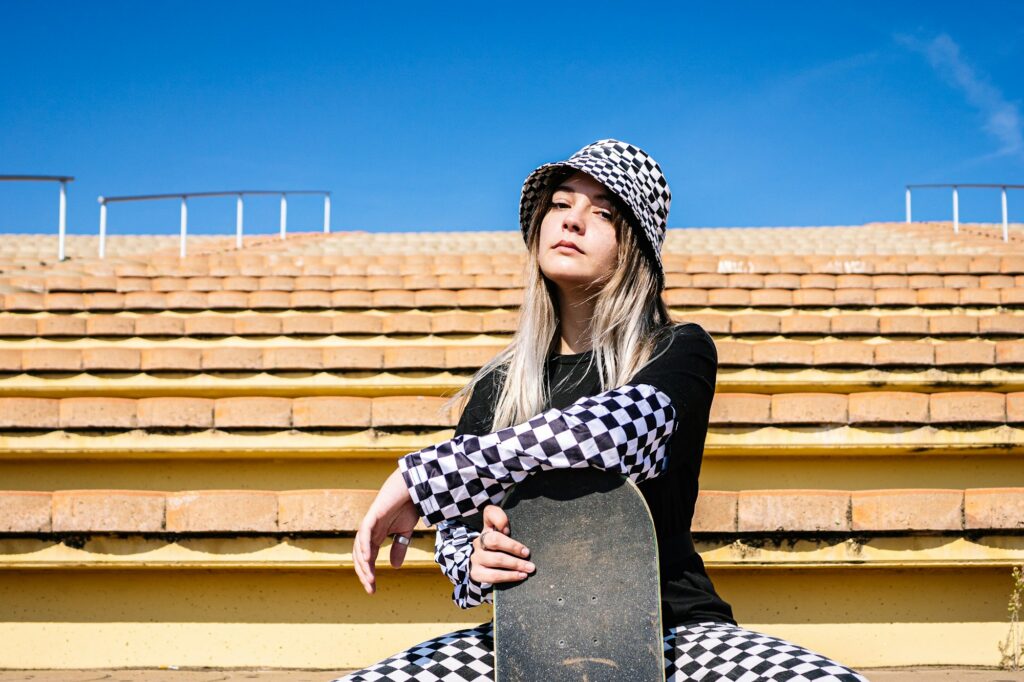 Stylish woman with skateboard on stairs